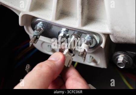 Retrait du capteur de thermostat électrique du lave-linge. Réparation de machines à laver Banque D'Images