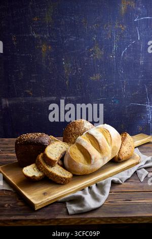 Série de pain artisanal rustique avec pains entiers et pain tranché sur planches et tables en bois. Style de boulangerie ferme avec des textures naturelles, ingr organique Banque D'Images