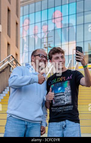 Wembley Park, Londres, Royaume-Uni. 22 août 2025. Les premiers fans de Coldplay arrivent à Wembley Park. Avant la série de concerts de groupes au stade de Wembley, à partir de ce soir, les super fans arrivant tôt, Pierre et Enzo de Normandie, en France, visitent l'installation d'art public de Wembley Park, en collaboration avec Pantone, 'YELLOW 25' sur les marches espagnoles, un gradient de 58 marches jaunes pour célébrer le 25e anniversaire de la chanson de Coldplay 'Yellow'. Crédit : Amanda Rose/Alamy Live News Banque D'Images