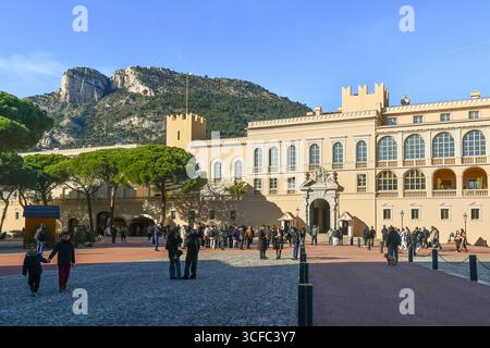 Vue sur la place du Palais avec les gens devant le Palais Royal et le promontoire de TETE de chien en arrière-plan, Monaco ville, Principauté de Monaco Banque D'Images