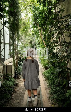 Enfant fille marchant dans la serre tropicale. Banque D'Images