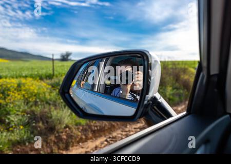 Reflet dans le miroir de voiture prenant la photo Banque D'Images