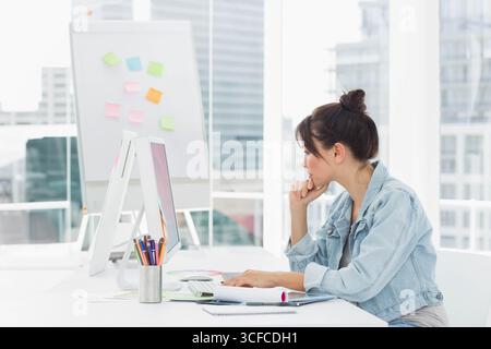 Ordinateur de bureau affichant des documents alors que le gobelet à crayons avec des crayons repose près de la fenêtre Banque D'Images