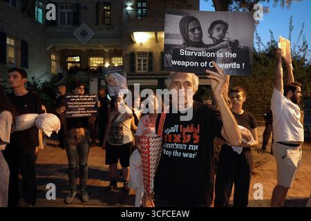 HAÏFA, ISRAËL - 21 AOÛT : des manifestants arabes israéliens et des militants de la paix tiennent des pancartes condamnant la guerre, ainsi que des photos d'enfants palestiniens et de journalistes tués par l'armée israélienne à Gaza lors d'une manifestation contre la guerre israélienne dans la bande de Gaza le 21 août 2025 à Haïfa, en Israël. Banque D'Images