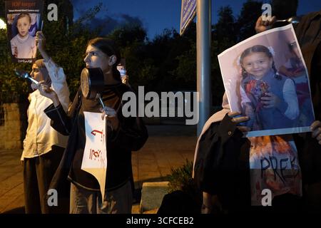 HAÏFA, ISRAËL - 21 AOÛT : des manifestants arabes israéliens et des militants de la paix ont frappé des pots alors qu'ils tenaient des pancartes condamnant la guerre, aux côtés de photos d'enfants palestiniens et de journalistes tués par l'armée israélienne à Gaza lors d'une manifestation contre la guerre d'Israël dans la bande de Gaza le 21 août 2025 à Haïfa, en Israël. Banque D'Images