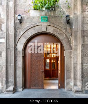 Grande mosquée Kayseri, alias Ulu Camii entrée à Kayseri, Turquie. Porte en bois sculpté ornée dans une arche en pierre historique, ornée d'un signe de calligraphie arabe Banque D'Images