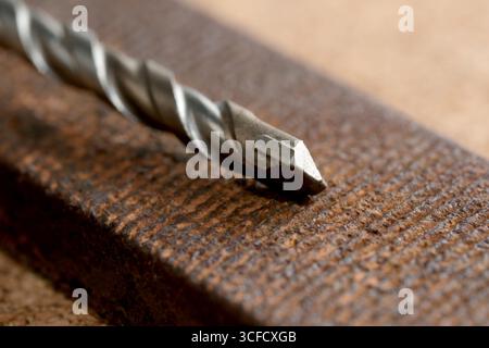 Un foret rouillé sur bois texturé met en valeur l'essence de l'artisanat. Banque D'Images