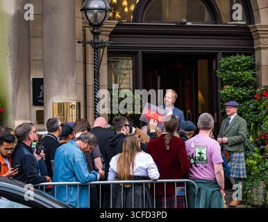 Balmoral Hotel, Princes Street, Édimbourg, Écosse, Royaume-Uni 22 août 2025. Les foules attendent et encouragent Brian Johnson du groupe AC/DC alors qu'il part après le concert de Murrayfield. La section ouest de Princes Street a été fermée en raison de la foule de fans. Crédit : Sally Anderson/Alamy Live News Banque D'Images