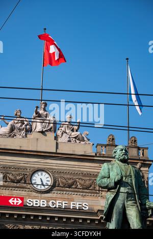 Zurich, Suisse, 19 août 2025. Façade d'entrée du bâtiment de la gare centrale de Zurich HB avec la statue d'Alfred Escher au premier plan. Regardant vers le haut shot, su Banque D'Images