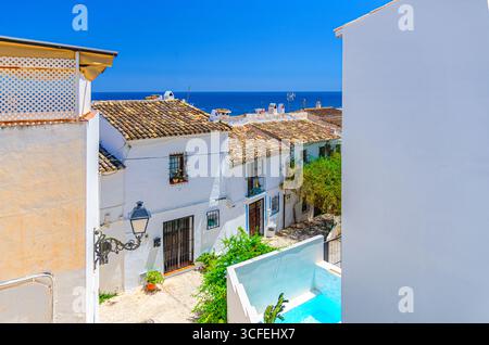 Altea vieille ville rue étroite avec des maisons blanches typiques bâtiments traditionnels, Altea Bay eau de mer Méditerranée dans la journée ensoleillée d'été, histoire de la ville d'Altea Banque D'Images