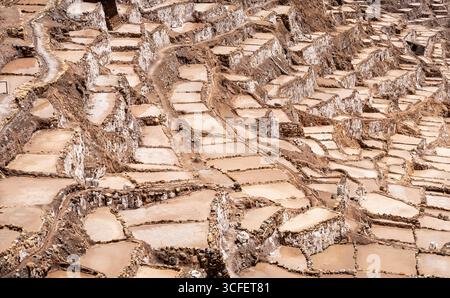 Les étangs salants de Maras descendent une colline en terrasses dans la Vallée sacrée du Pérou. Banque D'Images
