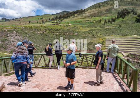Cusco, Pérou - 15 mars 2025 : groupe de touristes à un point de vue profitant de la vue sur les terrasses agricoles du site archéologique de Moray Banque D'Images