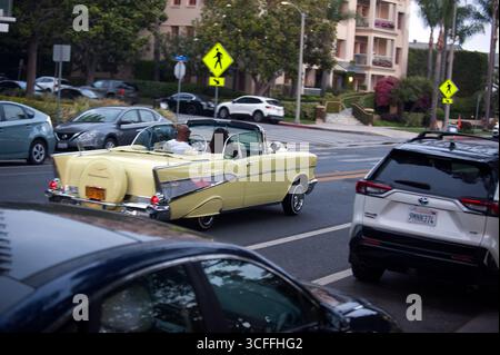 Couple conduisant dans une voiture décapotable classique à Santa Monica, Californie, États-Unis Banque D'Images