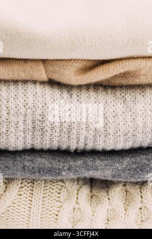Une pile soigneusement empilée de pulls en tricot confortables dans des tons neutres Banque D'Images