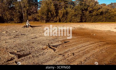 Réservoir Ardingly dans le Sussex de l'Ouest. 22 août 2025, réservoir aride et sec, femelle regardant sur une zone épuisée après l'été le plus chaud sur record UK Banque D'Images