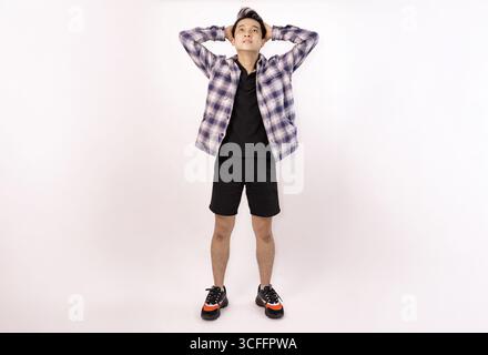 jeune homme posant décontracté dans une tenue tendance sur un fond uni Banque D'Images
