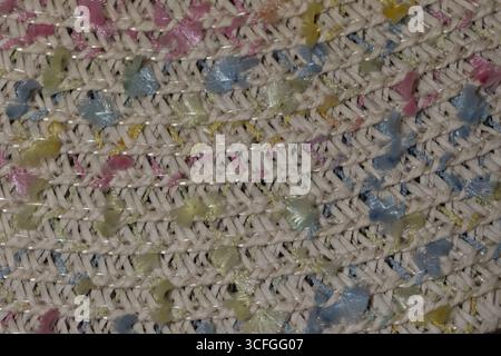 Ce gros plan montre un tissu tissé détaillé avec une variété de couleurs pastel mélangées avec des fils blancs, créant une apparence texturée et vibrante qui ajoute du charme à n'importe quel cadre. Banque D'Images
