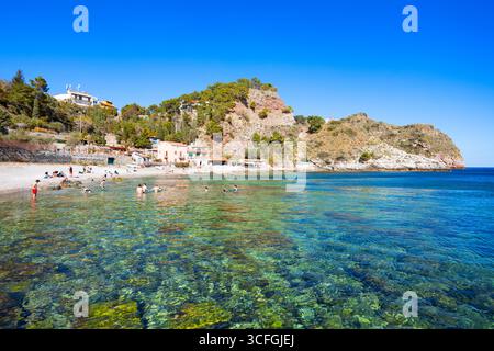 Taormina, Italie - 27 mars 2023 : des personnes non identifiées nagent à la plage d'Isola Bella à Taormina. Taormina est une ville sur la côte est de l'île Banque D'Images
