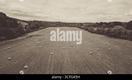 Vue aérienne par drone de terres agricoles avec des balles de foin rondes après récolte dans la campagne du Worcestershire, en Angleterre – paysage agricole britannique rural Banque D'Images