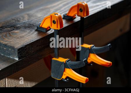 Charpentier deux pinces sont fixées aux planches, gros plan. Outils de menuiserie dans l'atelier de la maison Banque D'Images