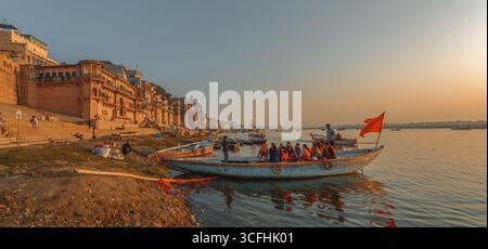 VARANASI, UTTAR PRADESH, INDE - 9 FÉVRIER 2024. Un groupe de touristes monte à bord d'un bateau pour une promenade le long du Gange à Varanasi. Inde Banque D'Images