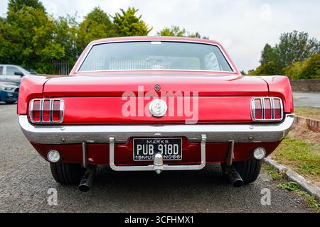 Vue arrière d'une Ford Mustang 1966 rouge classique garée à l'extérieur avec plaque d'immatriculation visible Banque D'Images