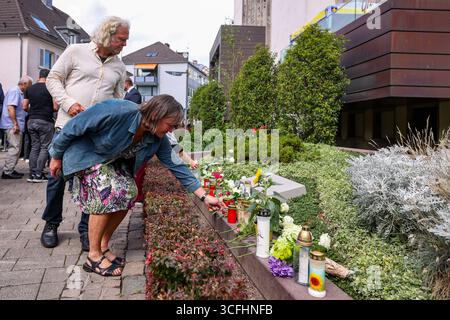 Solingen, Allemagne. 23 août 2025. Les proches des victimes déposent une rose blanche sur la pierre commémorative de l'attentat terroriste de Solingen. Crédit : Christoph Reichwein/dpa/Alamy Live News Banque D'Images