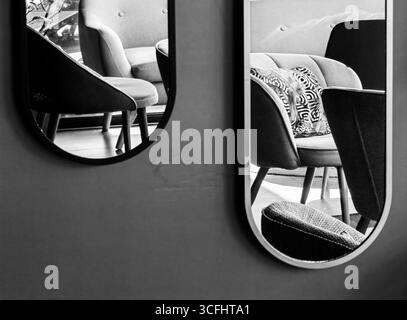 Miroirs muraux ovales reflets. Perspective créative. Intérieur du bar. Teintes monochromes. Banque D'Images