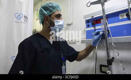 Médecin réglant les réglages du ventilateur à oxygène pour un patient à l'intérieur de l'unité de soins intensifs (USI). Alep, Syrie 18 octobre 2022, Alep, Syrie Banque D'Images