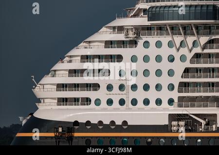 Un gros plan de l'arrière du bateau de croisière Disney Fantasy du côté pris dans la lumière du soleil du soir avec une seule personne regardant vers la mer. Banque D'Images