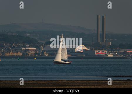 La compagnie du chantier naval Wight vue de Calshot Southampton par une soirée claire à travers le Solent avec les cheminées de la centrale Kingston en arrière-plan Banque D'Images