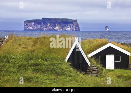 Cabanes traditionnelles en bois avec des toits d'herbe à Reykjadiskur avec l'île de Drangey à Skagafjoerdur, Norurland vestra, Islande Banque D'Images