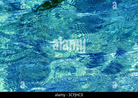 Gros plan de l'eau cristalline de la mer Adriatique avec des motifs abstraits et des reflets de la lumière du soleil, créant une texture naturelle parfaite pour les arrière-plans et d Banque D'Images