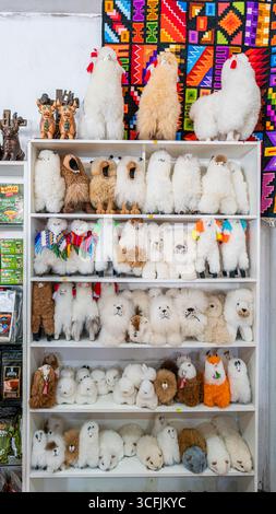 Jouets en peluche faits à la main en alpaga et lama exposés dans une boutique de souvenirs péruvienne. L'artisanat traditionnel attire les touristes à la recherche de cadeaux andins authentiques. Banque D'Images