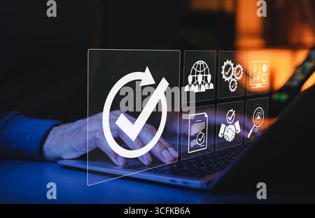 Assurance qualité et concept de conformité de certification. Personne utilisant un ordinateur portable avec des icônes représentant l'assurance qualité, la conformité, l'amélioration des processus Banque D'Images