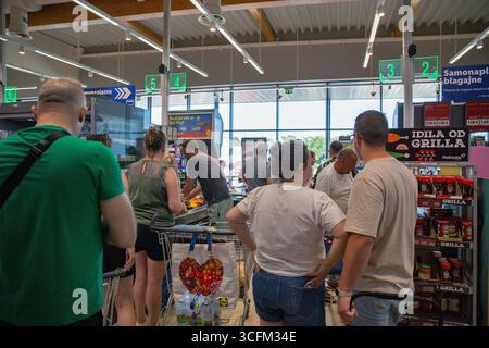 Porec, Croatie - 31 mai 2025 : les acheteurs font la queue aux caisses libre-service de l'épicerie contemporaine Lidl. Caisses numérotées avec gre Banque D'Images