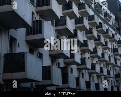 Berlin, Allemagne. 21 août 2025. 20.08.2025, Berlin. Balcons sur la façade en béton gris d'un nouveau bâtiment à Kreuzberg. Avec ses nombreux petits balcons, le bâtiment semble uniforme, monotone et anonyme. Beaucoup de ces nouveaux bâtiments avec beaucoup de petits appartements ont été érigés dans les quartiers du centre-ville ces dernières années. Les loyers au mètre carré sont souvent disproportionnellement élevés. Crédit : Wolfram Steinberg/dpa crédit : Wolfram Steinberg/dpa/Alamy Live News Banque D'Images