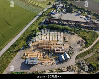 Entreprise de construction construisant des maisons en rondins de bois avec des grues capturées à partir d'une vue aérienne Banque D'Images