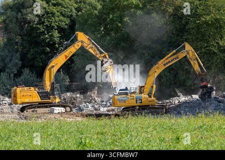 Herserange, France - vue sur deux pelles sur chenilles jaunes pour la démolition d'un vieux viaduc routier sur un chantier de construction. Banque D'Images