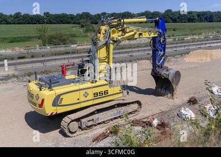 Wickrange, Luxembourg - vue sur une pelle sur chenilles jaunes Liebherr R 956 Litronic pour travaux de terrassement sur un chantier. Banque D'Images