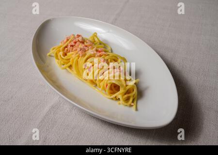 Tagliolini Al Salmone Affumicato e Panna, Vodka e Peperoncino pâtes italiennes avec saumon, vodka et piment dans une sauce crème Banque D'Images