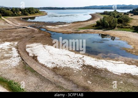 Les faibles niveaux d’eau et le lit du lac desséché sont exposés au lac Chew Valley, dans le Somerset Nord, où Bristol Water rapporte des stocks d’eau (au 11/08/2025) à 44 % comparativement à 73 % l’an dernier en 2024. Date de la photo : dimanche 24 août 2025. Banque D'Images