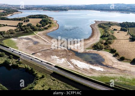 Les faibles niveaux d’eau et le lit du lac desséché sont exposés au lac Chew Valley, dans le Somerset Nord, où Bristol Water rapporte des stocks d’eau (au 11/08/2025) à 44 % comparativement à 73 % l’an dernier en 2024. Date de la photo : dimanche 24 août 2025. Banque D'Images