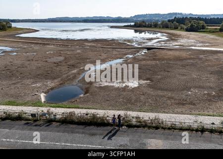 Les faibles niveaux d’eau et le lit du lac desséché sont exposés au lac Chew Valley, dans le Somerset Nord, où Bristol Water rapporte des stocks d’eau (au 11/08/2025) à 44 % comparativement à 73 % l’an dernier en 2024. Date de la photo : dimanche 24 août 2025. Banque D'Images