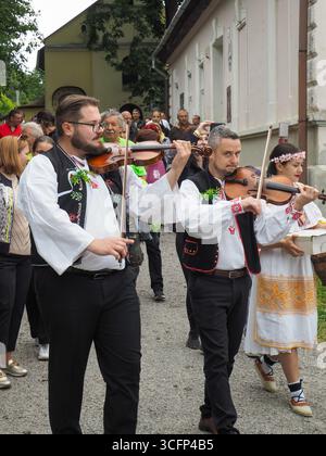 Procession traditionnelle de mariage avec des violonistes dans le village de Vlkolínec classé au patrimoine de l'UNESCO Banque D'Images