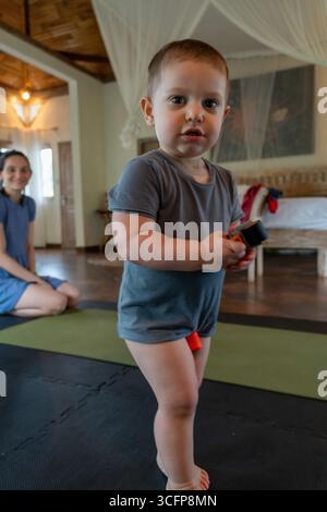 Adorable garçon joue avec sa mère pas trop loin. Banque D'Images
