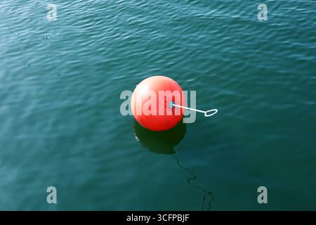Bouée orange de marquage de traînée d'eau flottant à la surface de l'eau Banque D'Images