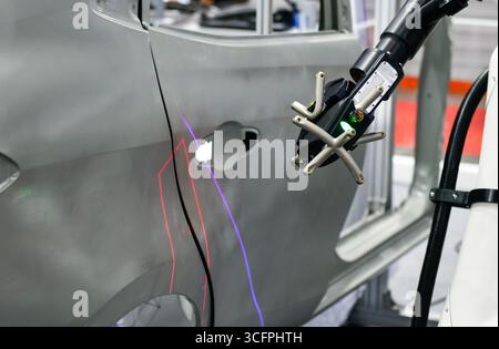 Scanner 3D sur bras robotisé mesurer la précision des pièces automobiles. dans les installations industrielles Banque D'Images