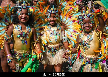 Londres, Royaume-Uni. 24 août 2025. Participants et fêtards à la parade annuelle des enfants sur le carnaval de Notting Hill dimanche. Le carnaval de Notting Hill à Londres est le plus grand festival de rue d'Europe et le deuxième plus grand carnaval de rue du monde après Rio, attirant régulièrement environ 2 millions de personnes pendant le jour férié. Crédit : Imageplotter/Alamy Live News Banque D'Images