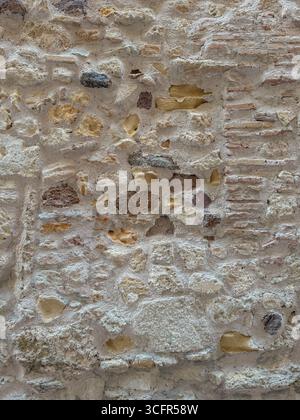 Gros plan de la surface murale altérée faite avec des pierres et des briques irrégulières Banque D'Images